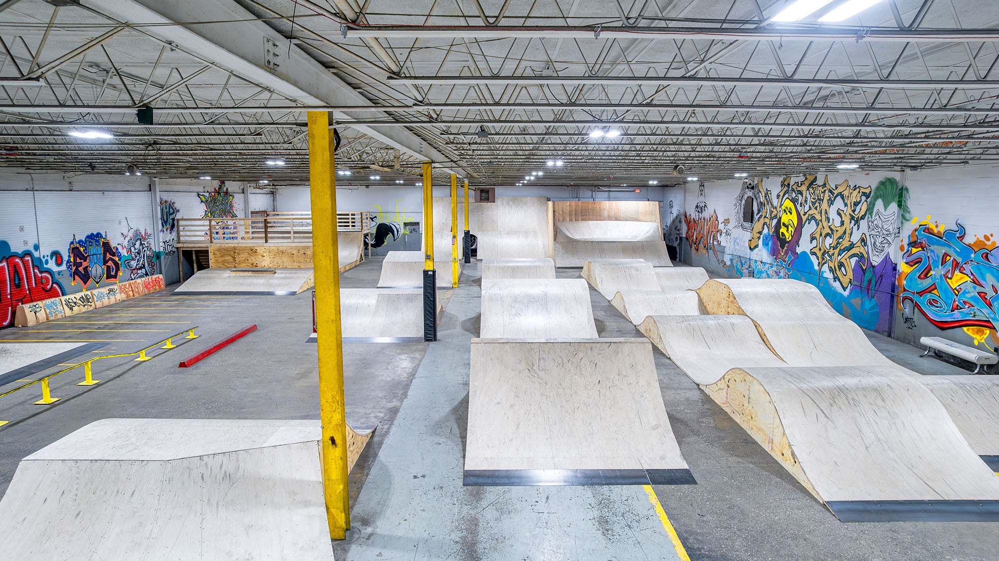 Indoor skate park with ramps and graffiti on the walls