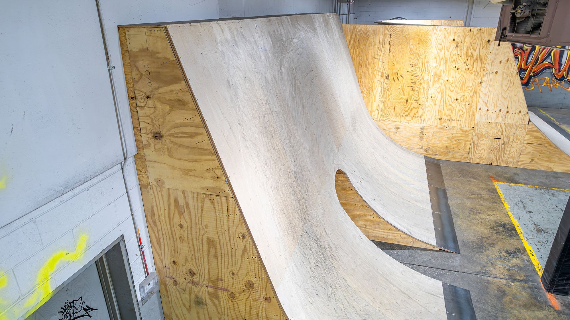 BMX ramp made of wood and concrete inside a building