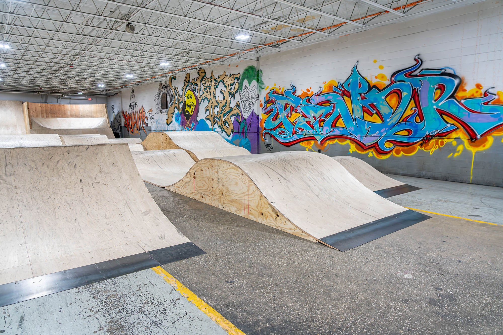 Skate park with ramps and graffiti art on the walls.