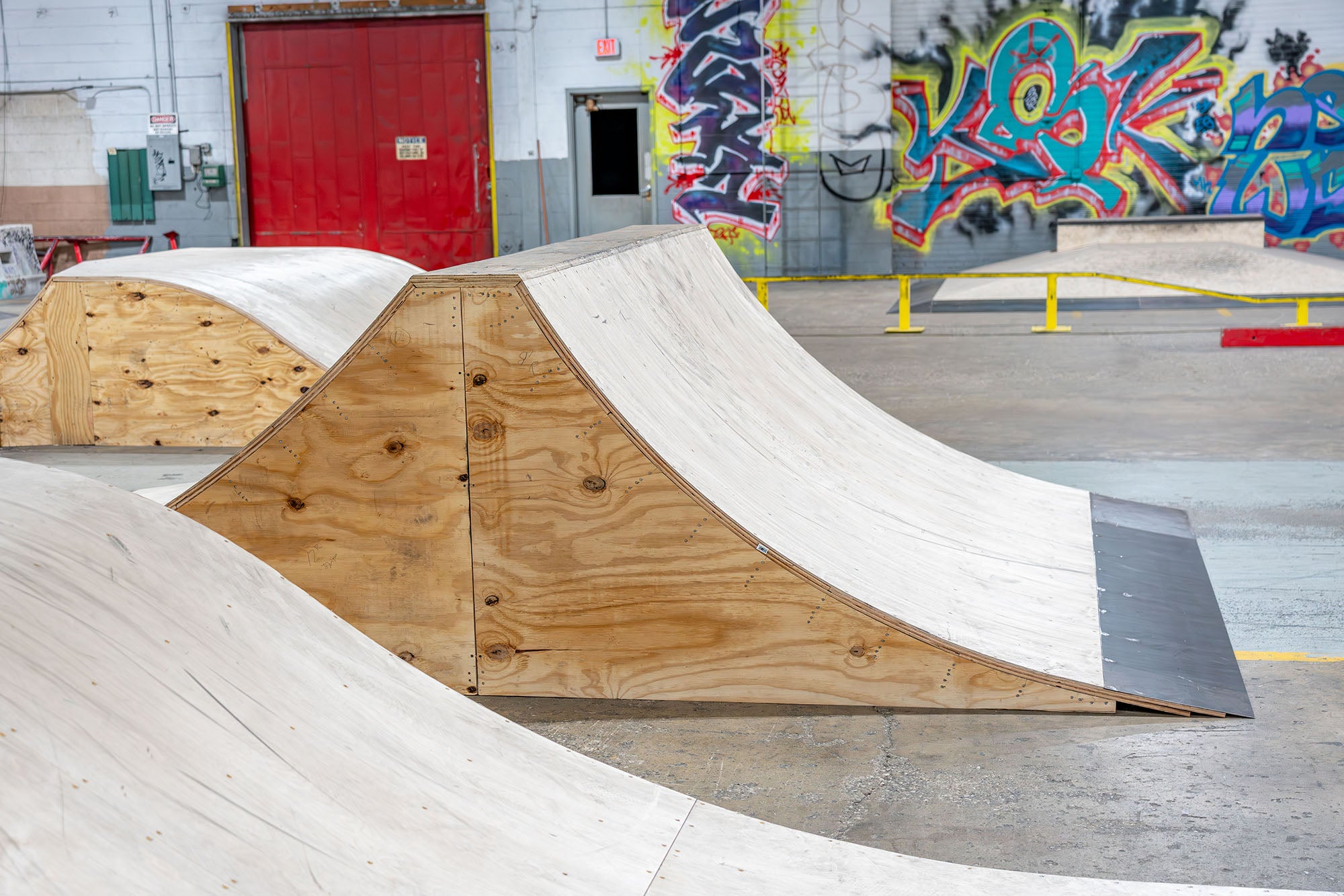 Wooden ramps with a graffiti-covered wall in the background