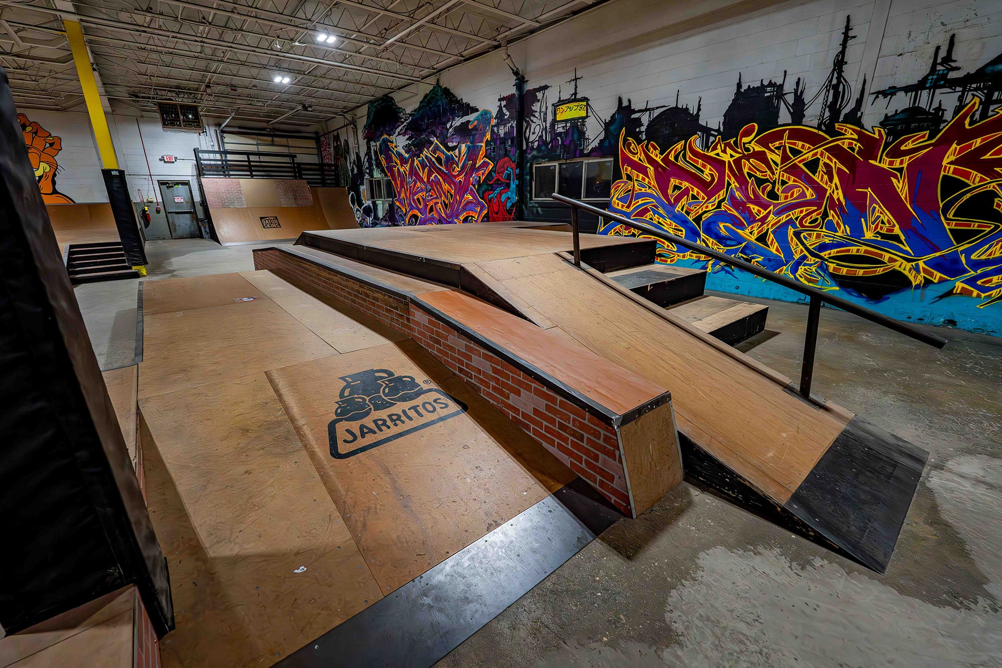 Skate park with ramps and graffiti art on the walls.